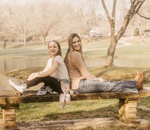 Friends relaxing on wooden pallets in a park during golden hour.