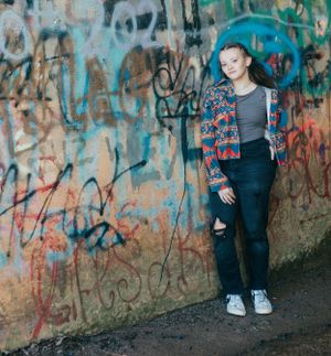 Urban photoshoot against colorful graffiti wall showing casual street style.
