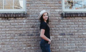 Casual fashion portraits against weathered brick architecture.