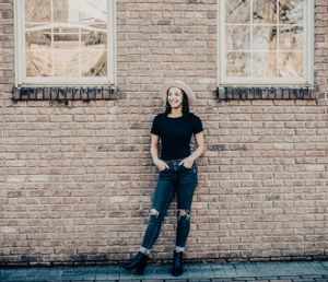 Street style portraits against a classic brick wall with windows.