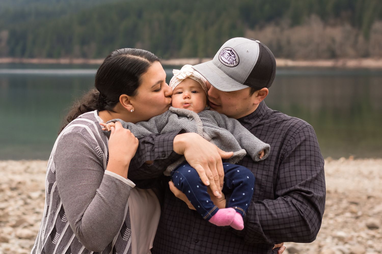 Mom and Dad kissing daughter on cheek at Alouette Lake in Maple Ridge