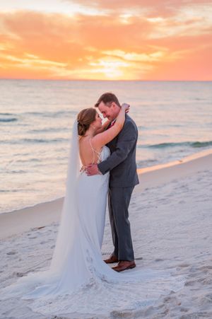 couple embracing each other on the beach on their wedding day at sunset on Panama City Beach Florida