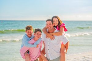 Fun family of four piggy backing on Panama City Beach