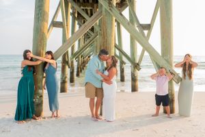 Fun family of 6 posing under pier on Panama City Beach Florida