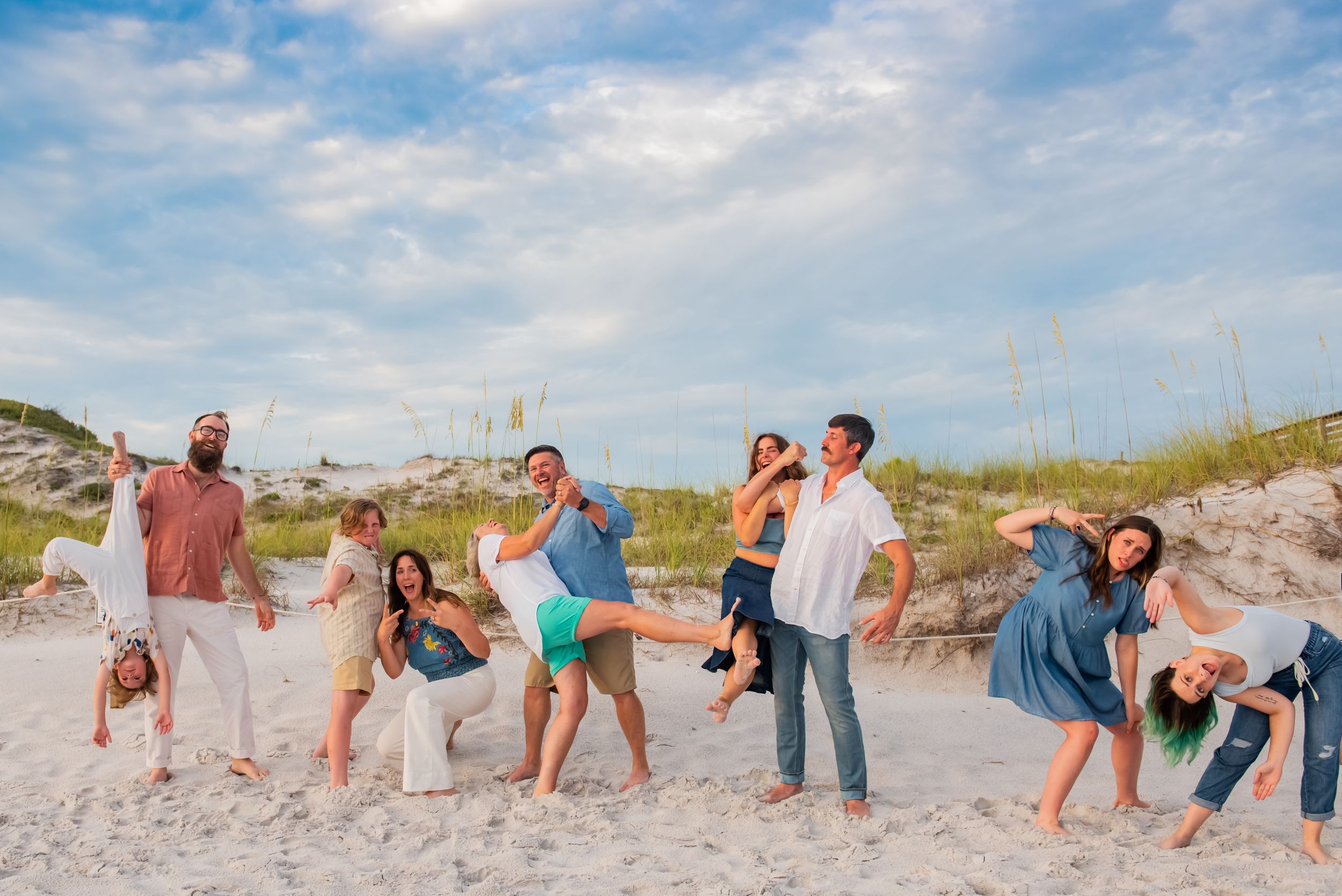 fun candid multi-family silly picture in front of sand dunes on Panama City Beach Florida during family beach photoshoot