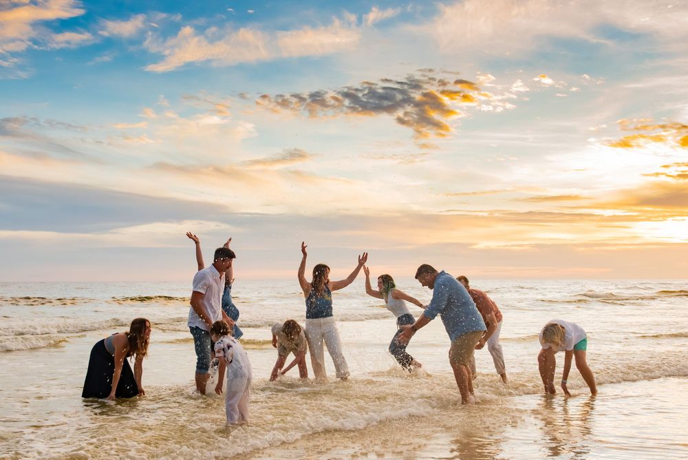 fun family playing and splashing in the water on Panama City Beach Florida at sunset during candid beach photo-session