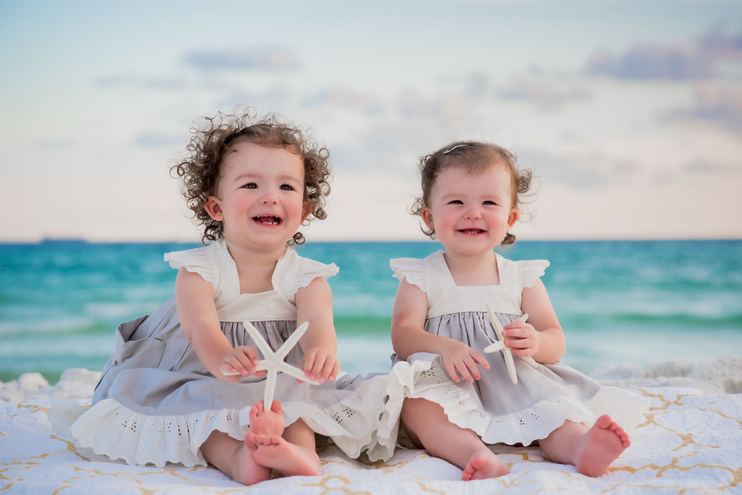 two kids sitting on the beach smiling during fun candid family beach portrait session on Panama City Beach Florida
