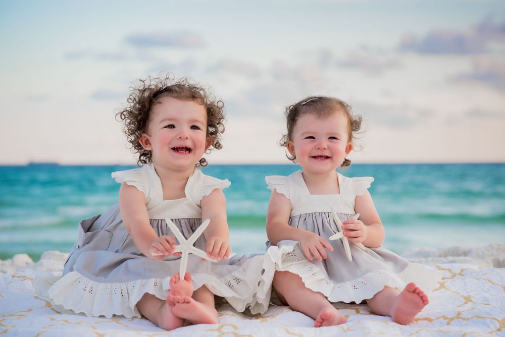 two kids sitting on the beach smiling during fun candid family beach portrait session on Panama City Beach Florida