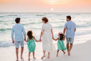 family beach portraits beautiful family of 5 walking on Panama City Beach at sunset