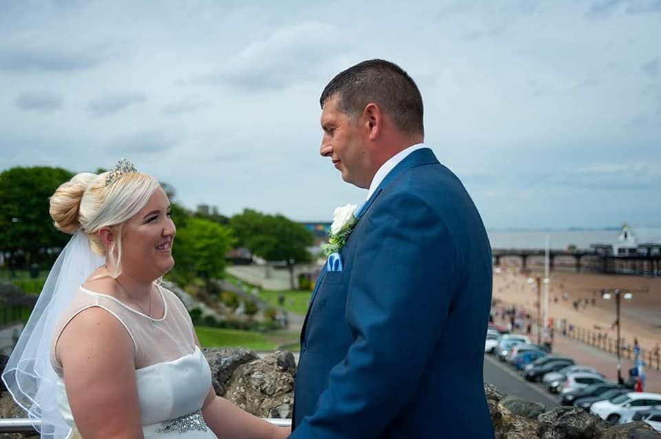 Wedding couple exchanges vows overlooking a coastal town on an overcast day.