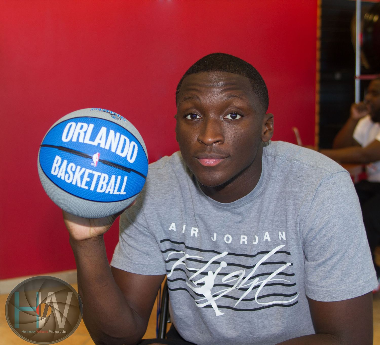 Basketball enthusiast holds Orlando team ball while wearing Air Jordan graphic t-shirt.