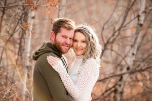 Intimate couple portraits among autumn trees with soft lighting.
