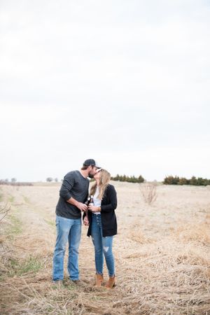 Couple sharing intimate moment in a golden wheat field.
