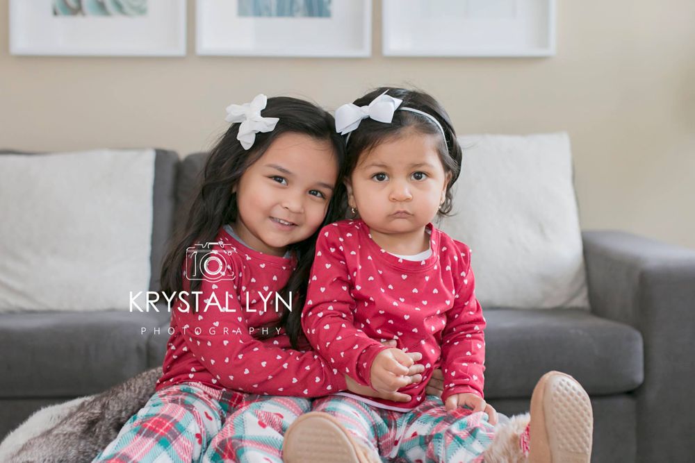 Two matching sister being photographed in their living room