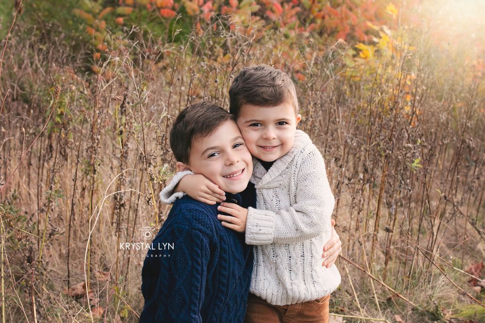 Two brothers embracing each other for a photo at golden hour