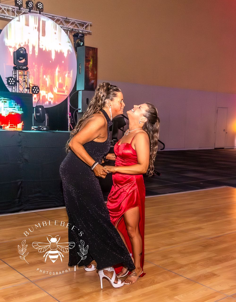 Two people in formal attire sharing a joyful moment on the dance floor.