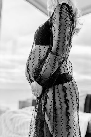 Artistic black and white photo showcasing intricate lace dress details.