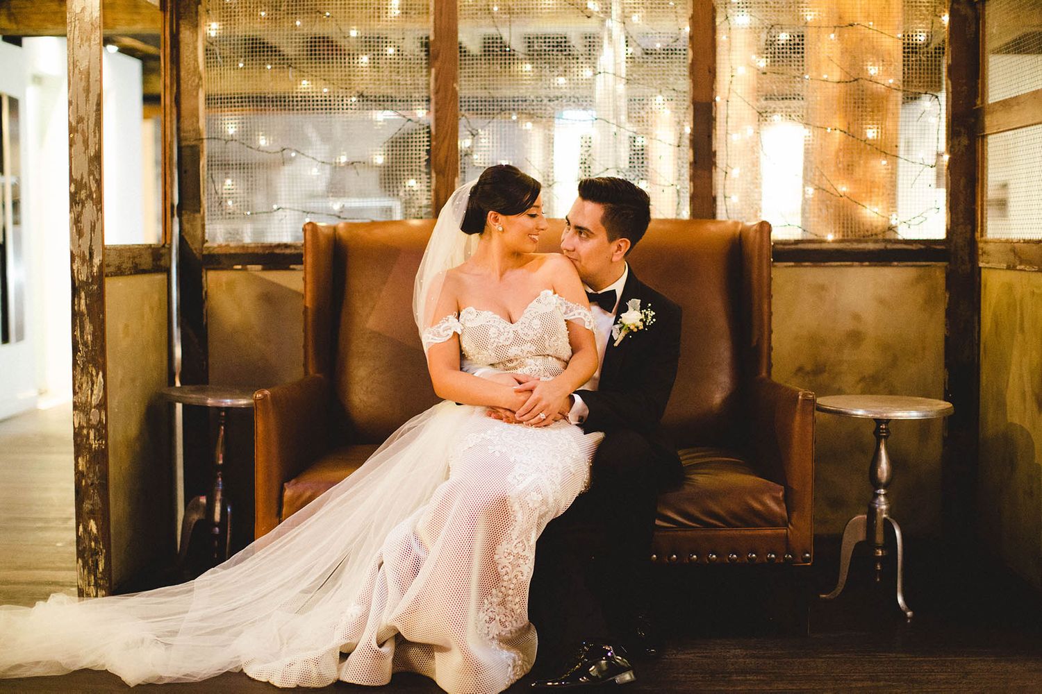 Romantic scene in rustic venue with warm lighting and vintage architectural details.