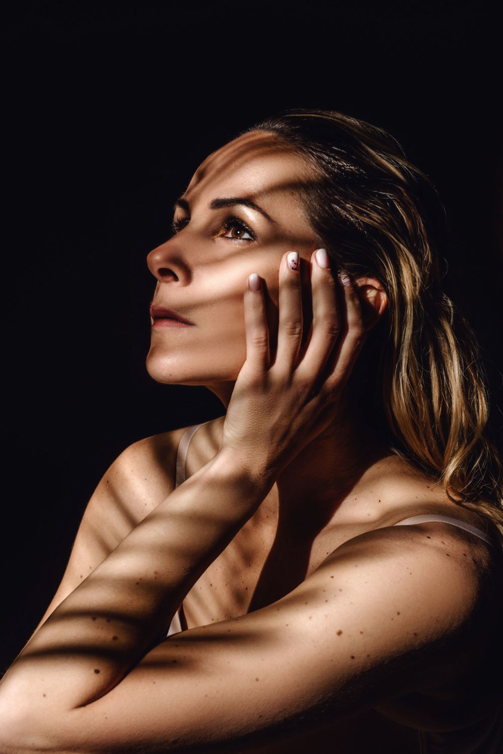 Artistic nude portrait series with dramatic shadows and lighting.