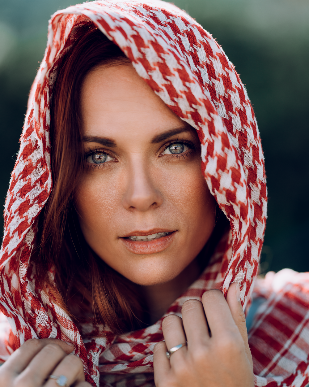 Portrait with red and white checkered headscarf in soft lighting.