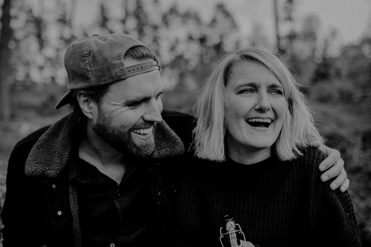 Black and white portraits showing a joyful couple embracing outdoors.
