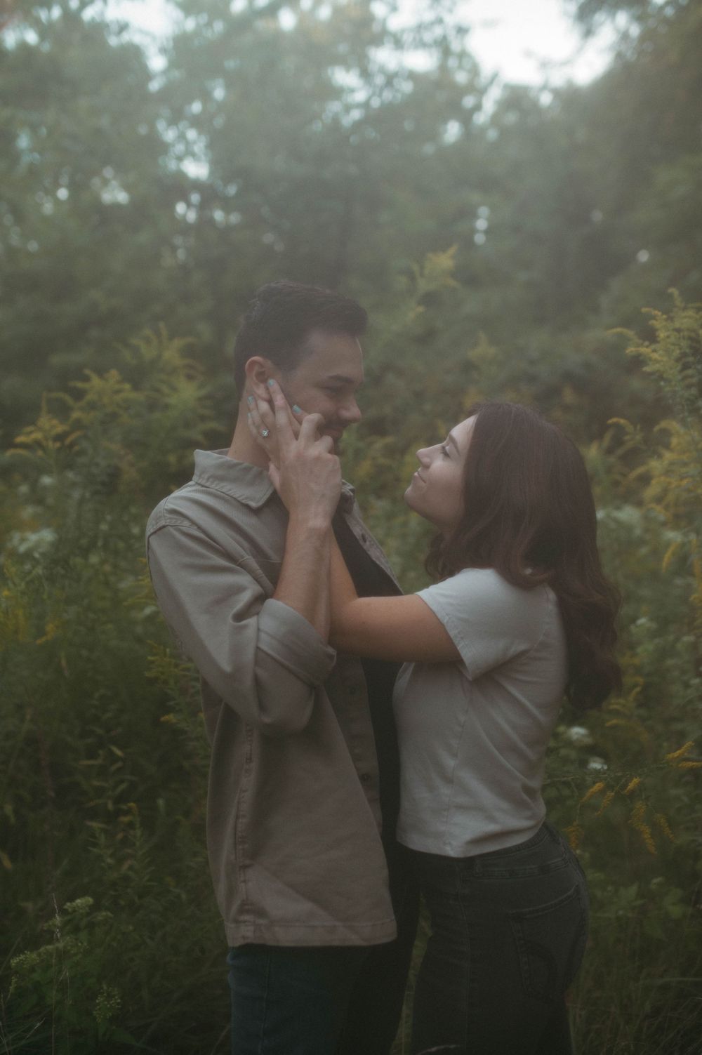 Emotional engagement moment captured in dreamy lighting among nature.