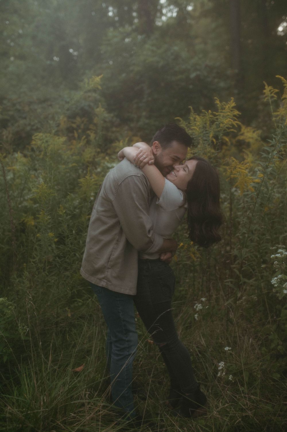 A passionate embrace captured in moody lighting with wild yellow flowers in the background.