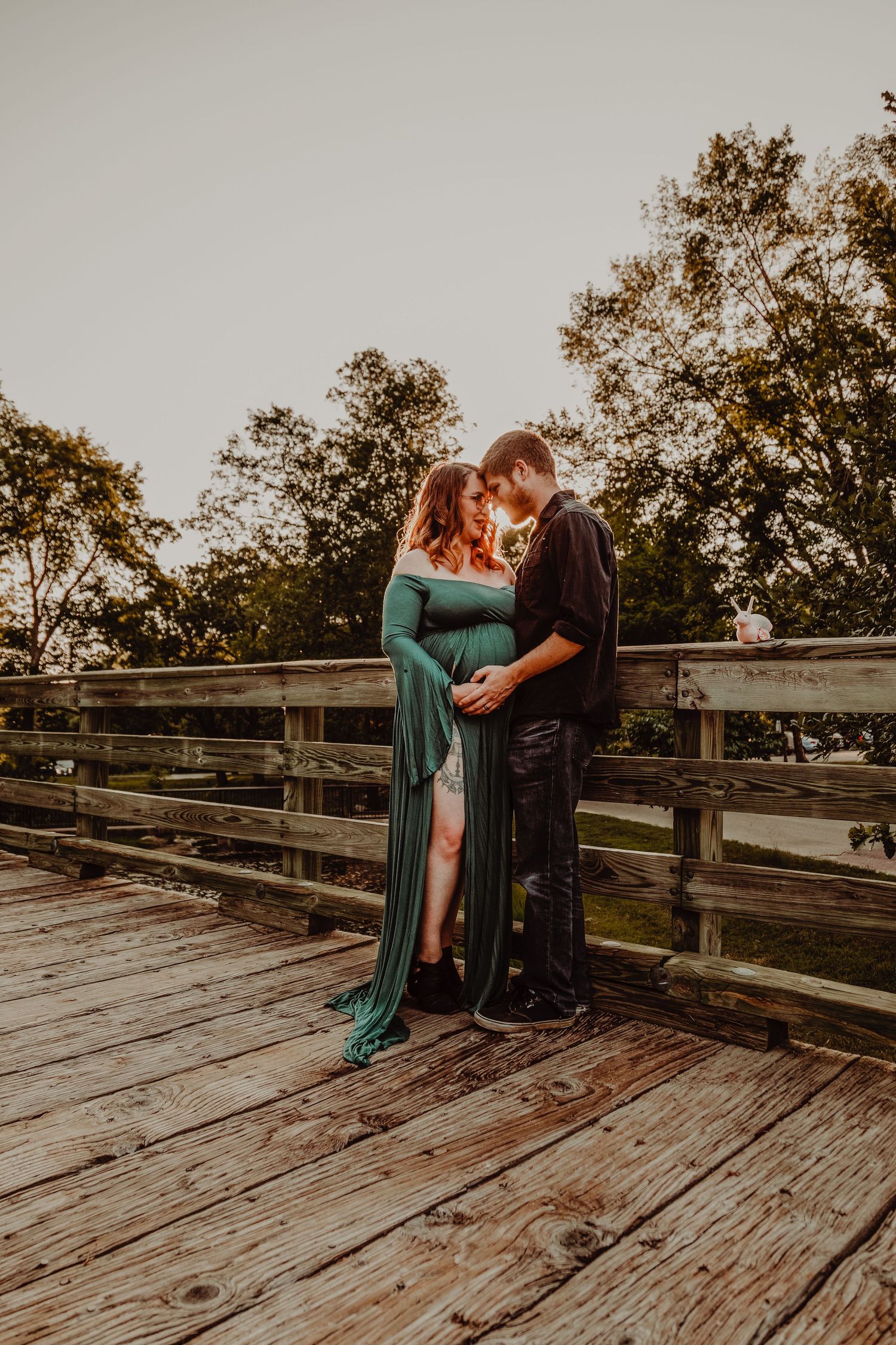 A romantic sunset moment captured on a wooden bridge deck surrounded by autumn trees.