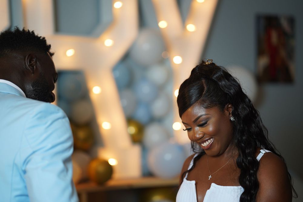A heartfelt moment during a marriage proposal with warm lighting and decorative lights in the background.