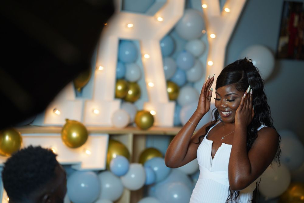 An emotional wedding moment captured with festive decorations and lights in the background.