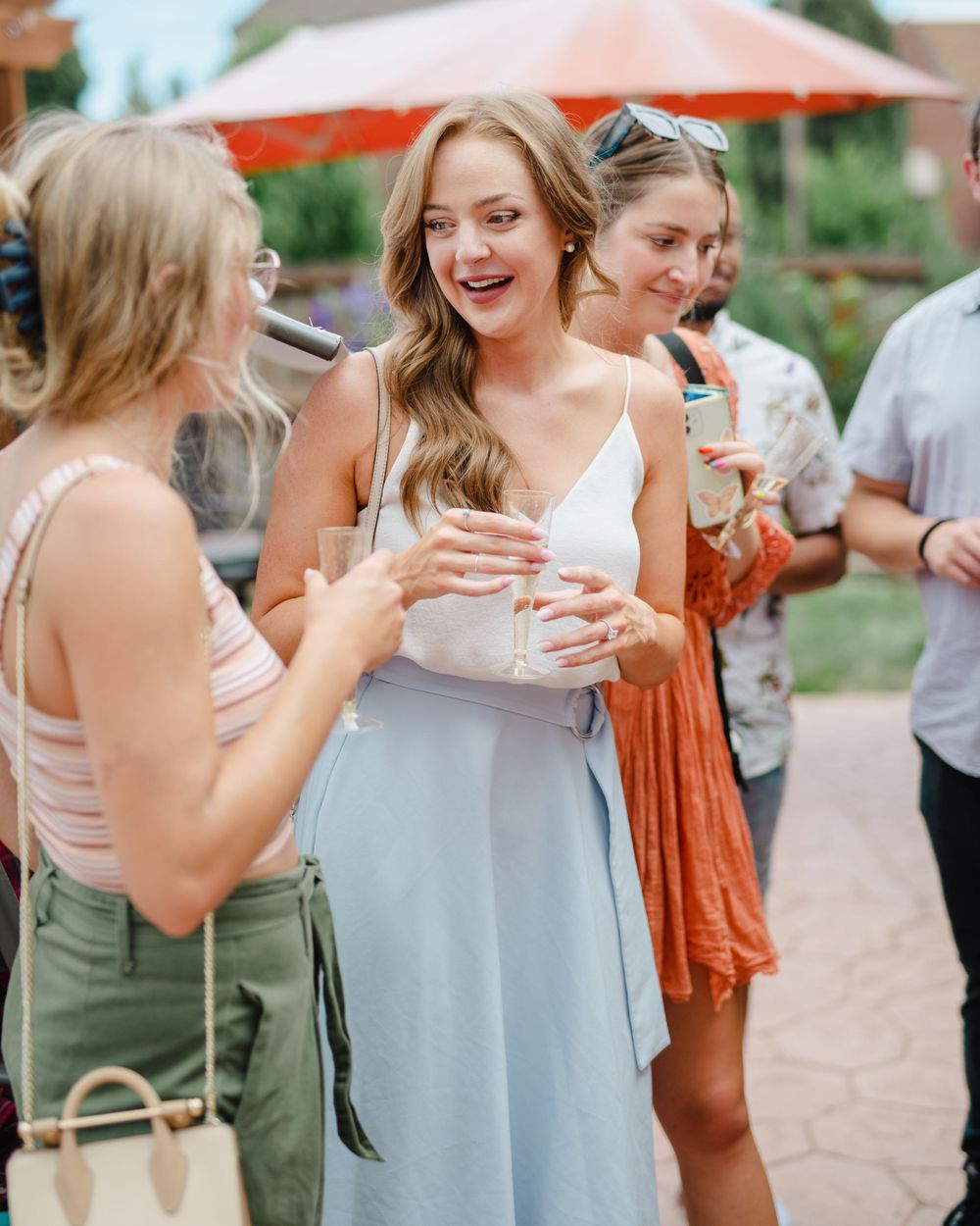 Friends share joyful moments at an outdoor celebration.