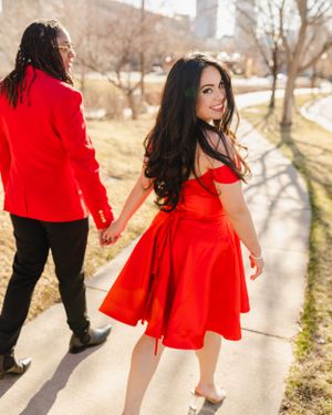 People in red outfits posing and celebrating outdoors on a sunny day.