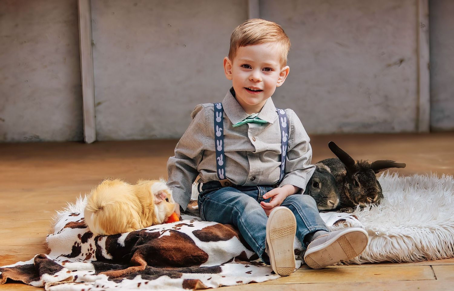 young famer boy feeding animals on floor