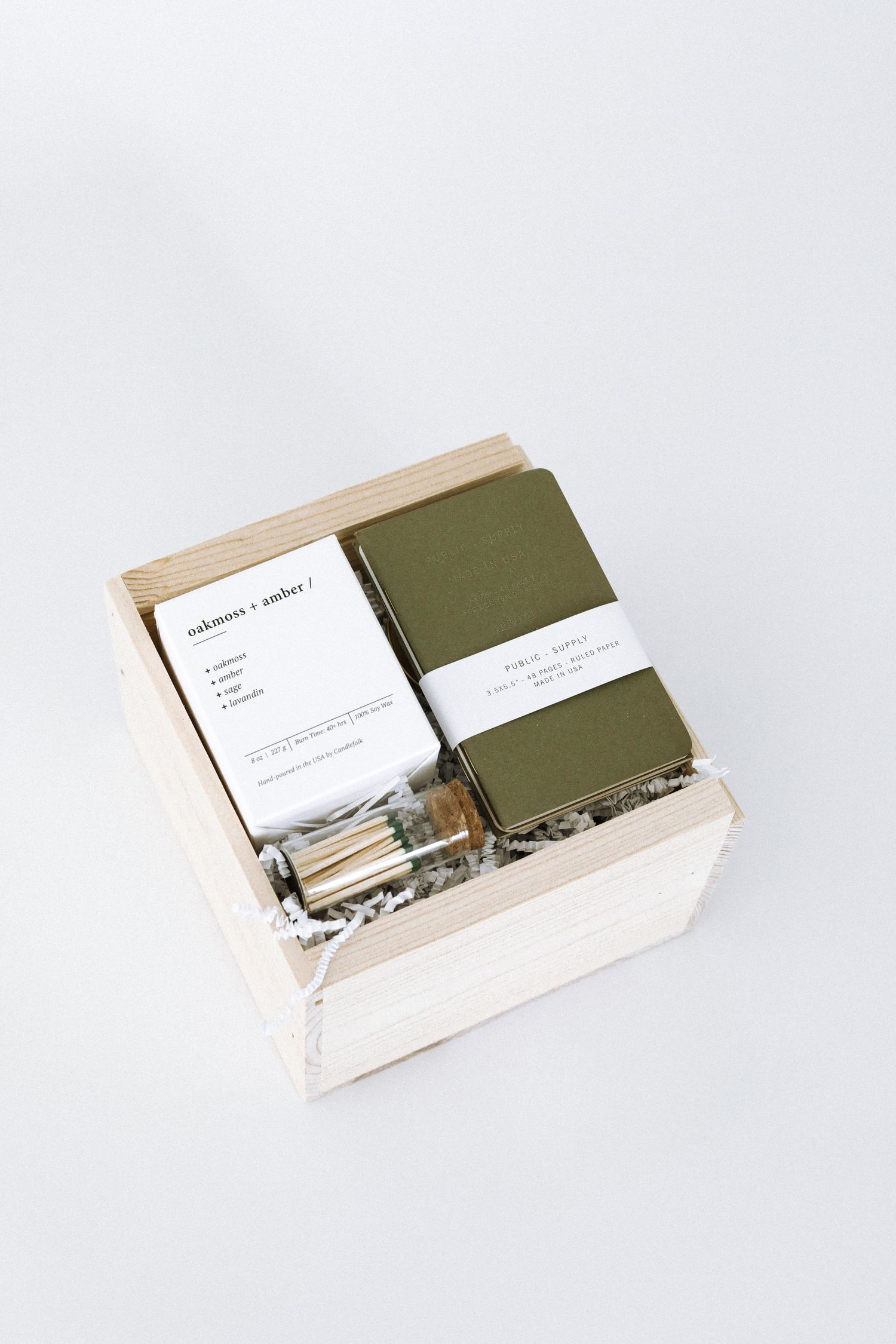 Minimalist stationery set with olive green notebook and cards in wooden box.