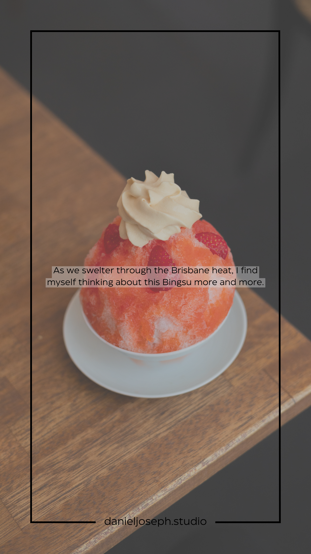 A bright red shaved ice dessert topped with whipped cream on a wooden table.