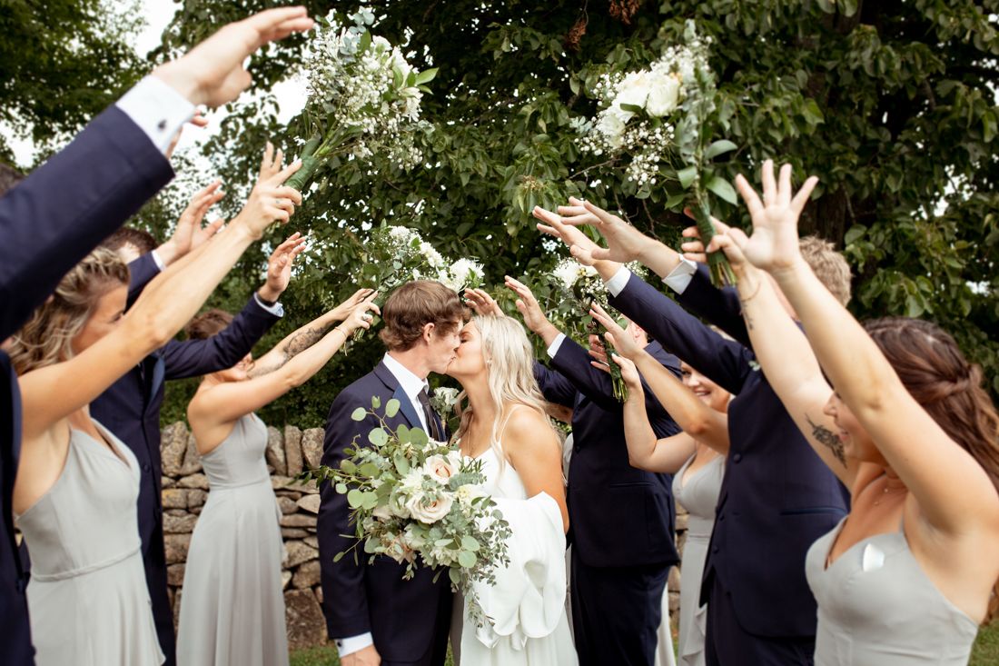 Bride and groom kissing in a love tunnel