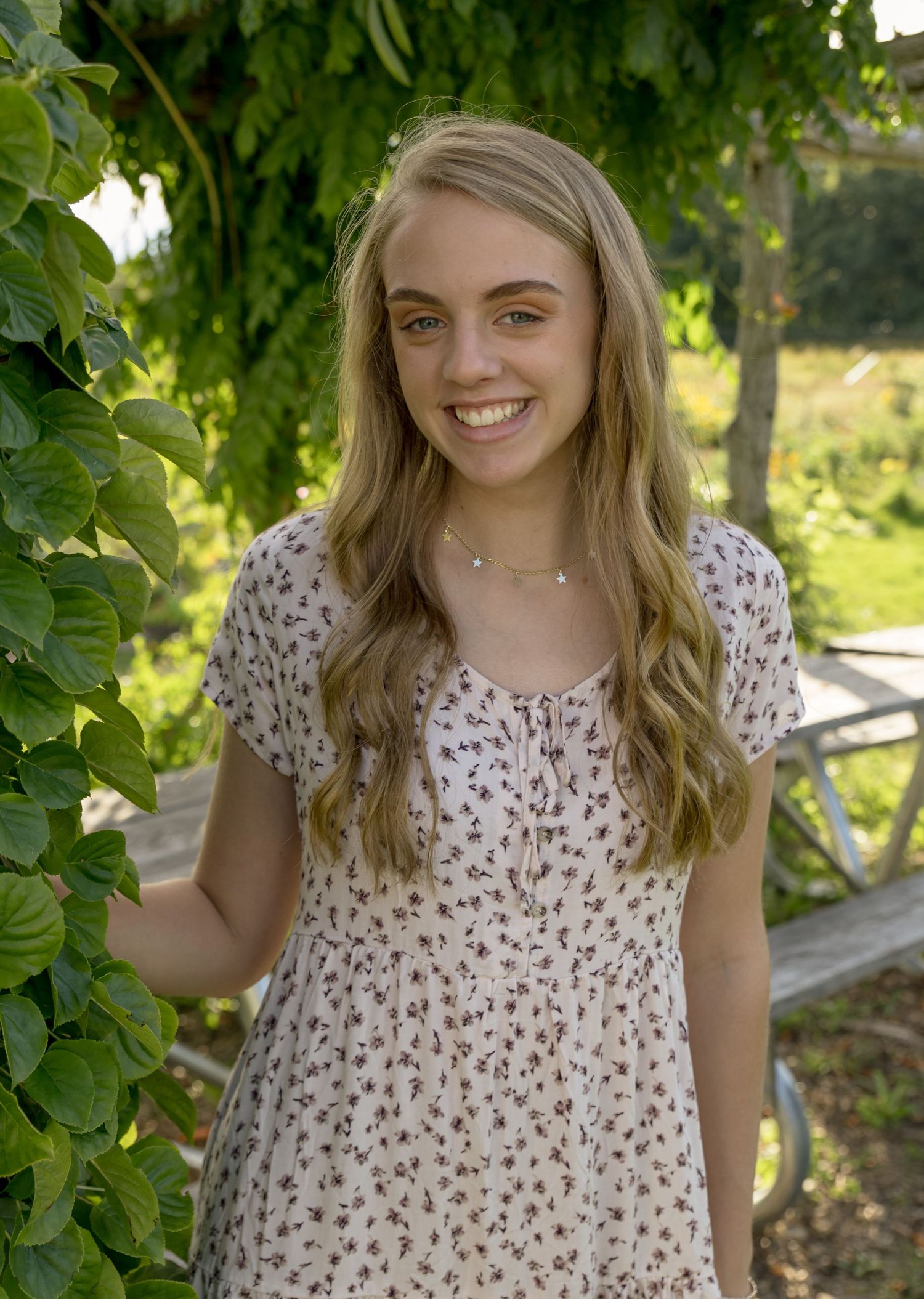 blond girl's senior portrait in front of an old barn flowered dress Belmont  NH.