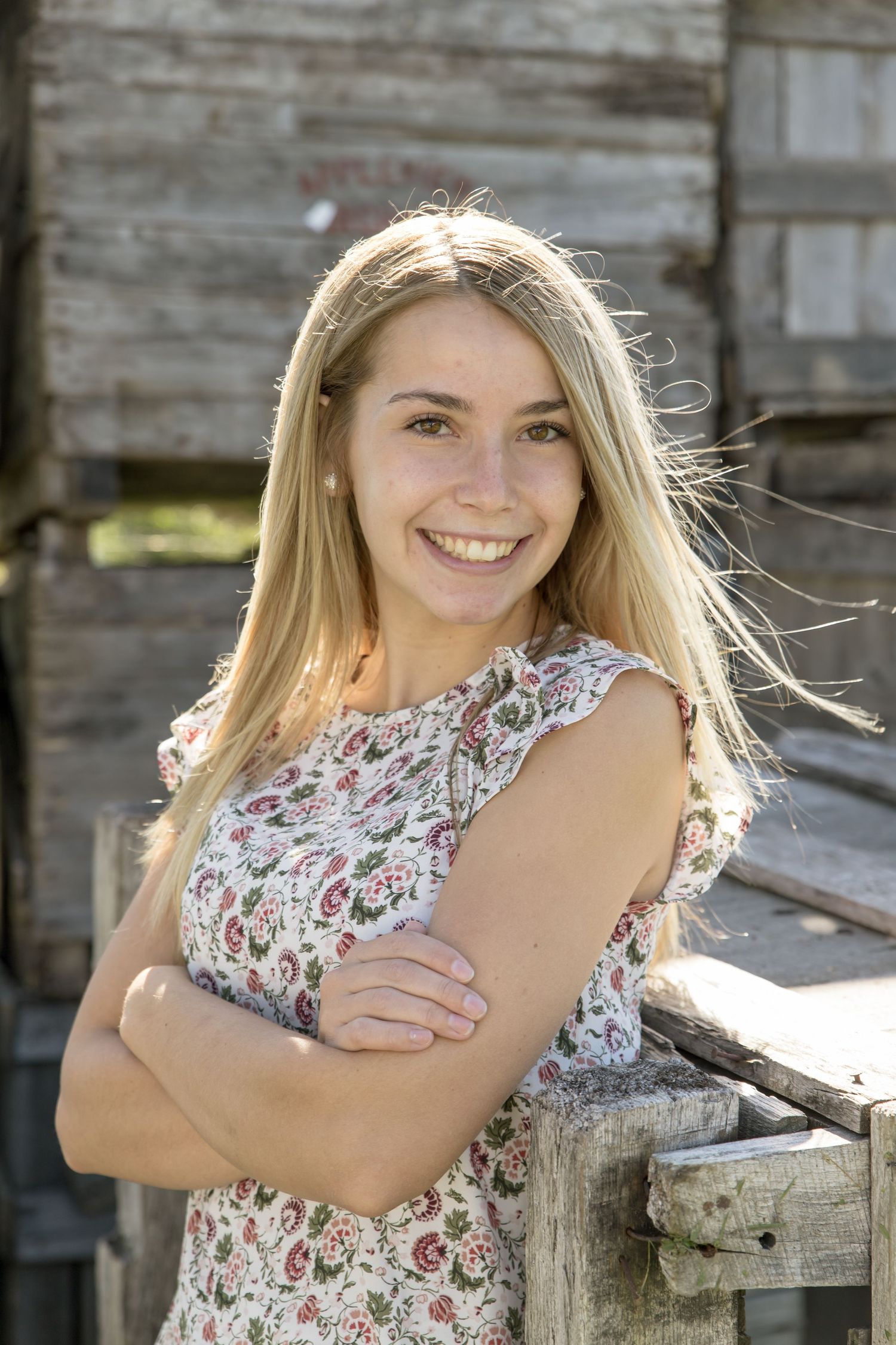 blond girl's senior portrait in front of an old barn flowered dress Belmont  NH.