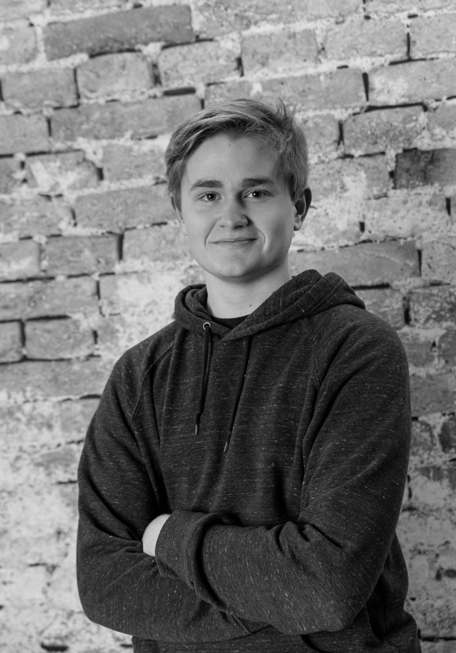 black and white boy's senior picture. dark hoodie medium hair wall background  farmington