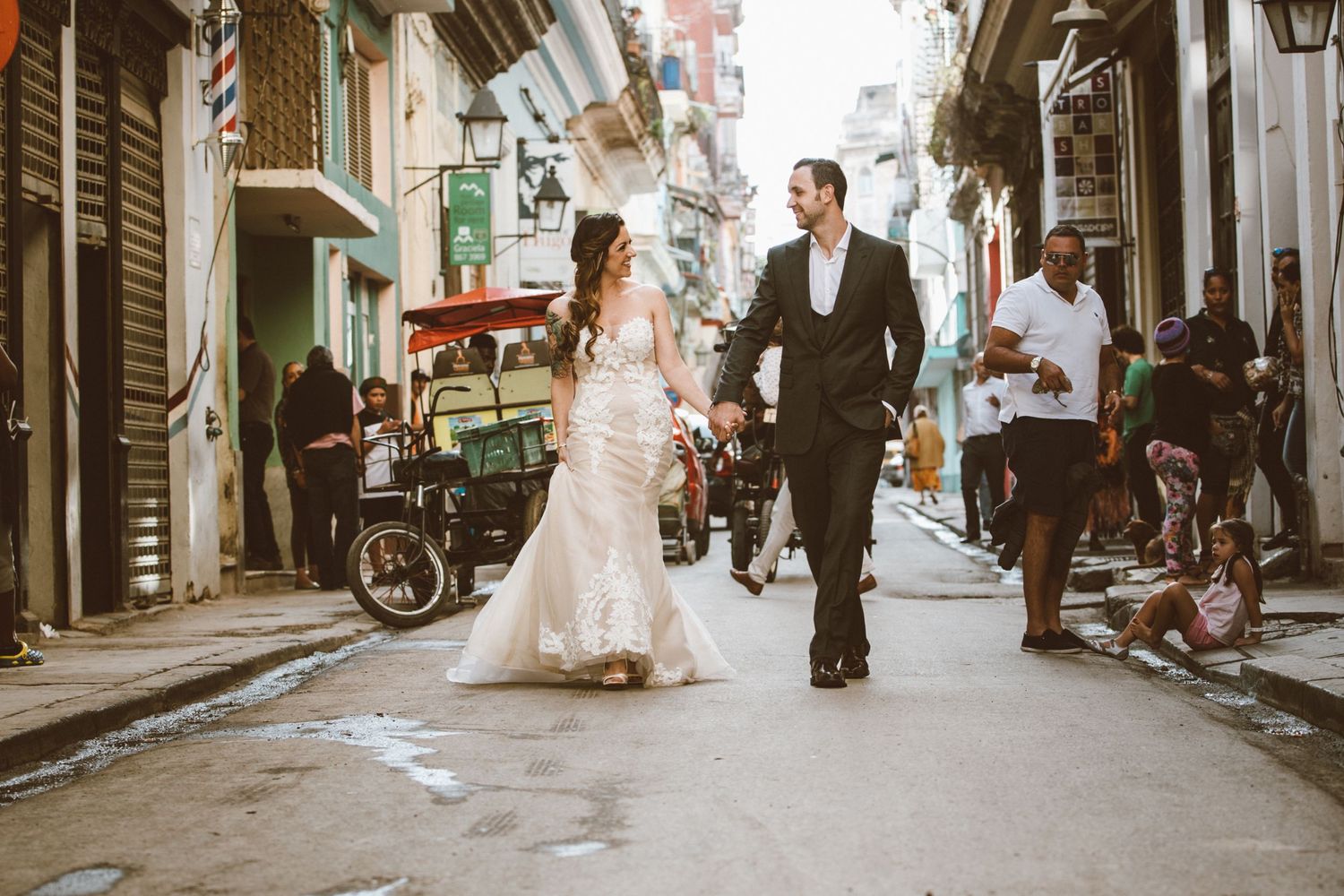 Wedding couple walks through charming European city streets with vintage architecture.