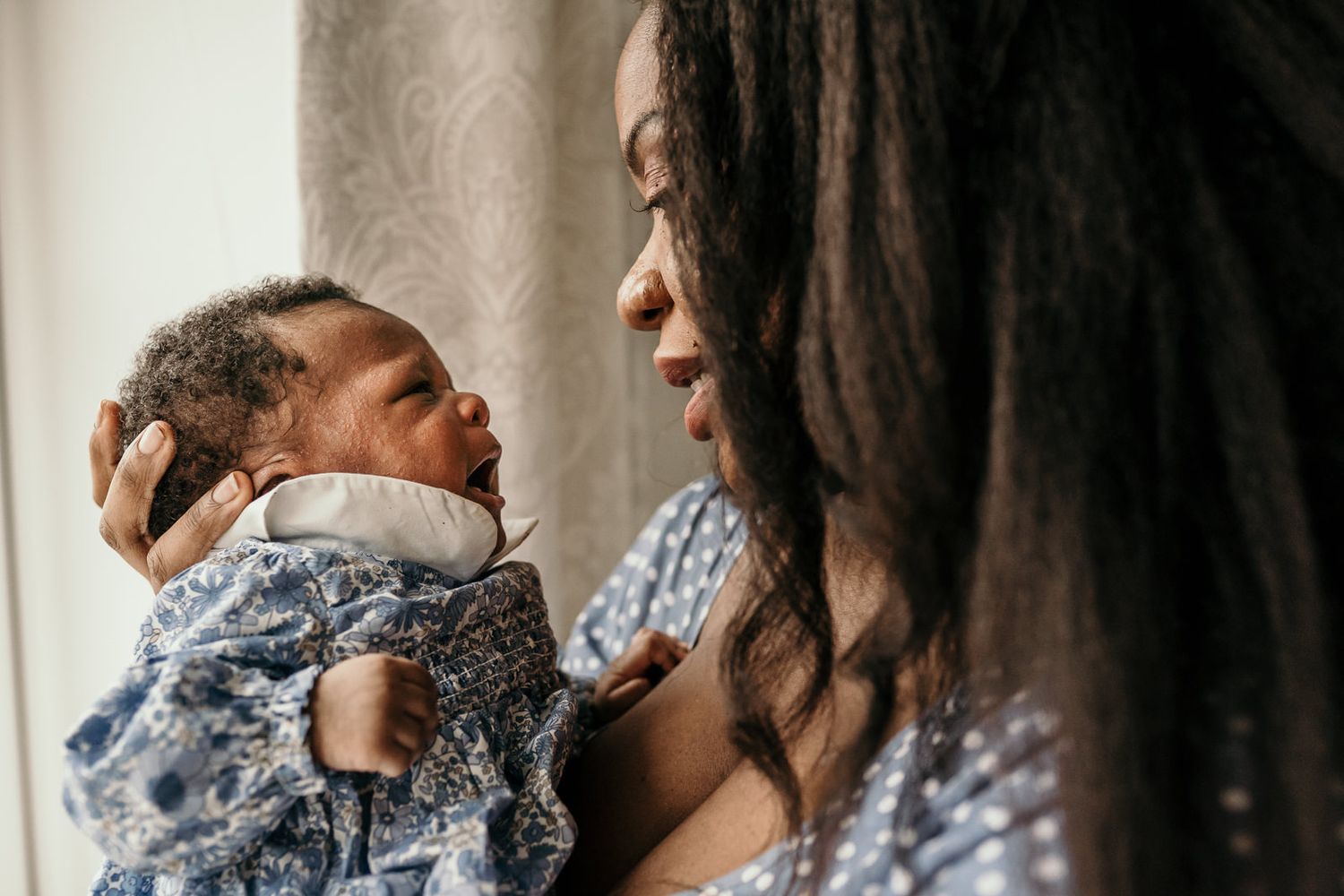 Close-up of a mother soothing her crying newborn baby