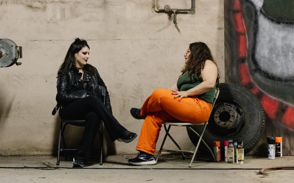 People sitting and resting against a wall during a production break.