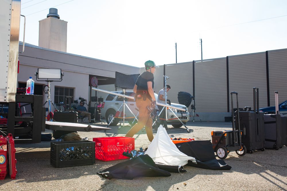 Production equipment and cases scattered outside on pavement near a building.