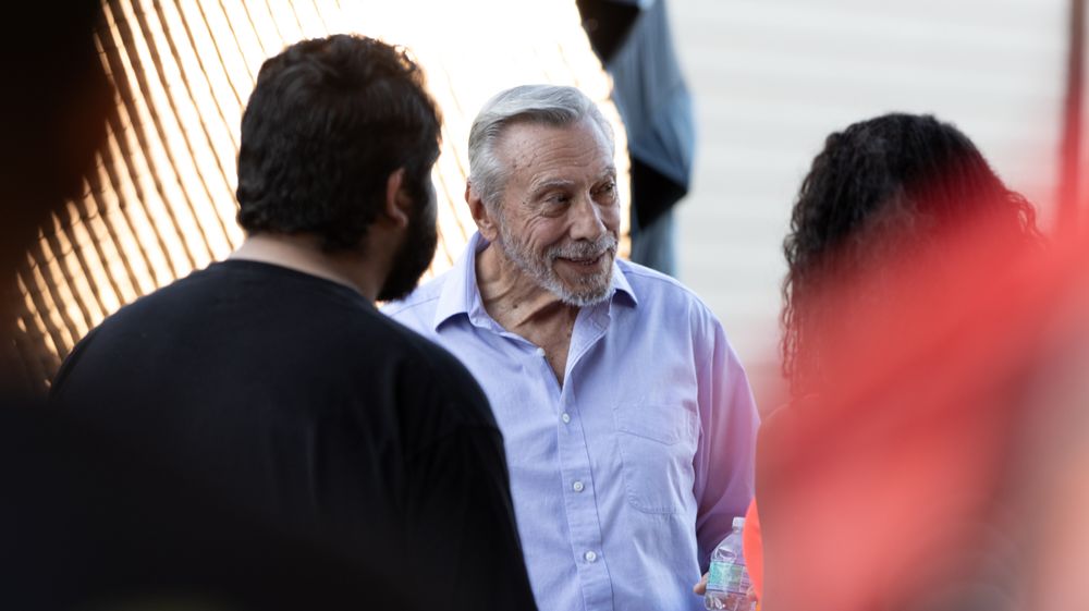 People gathered in casual conversation under dramatic lighting.