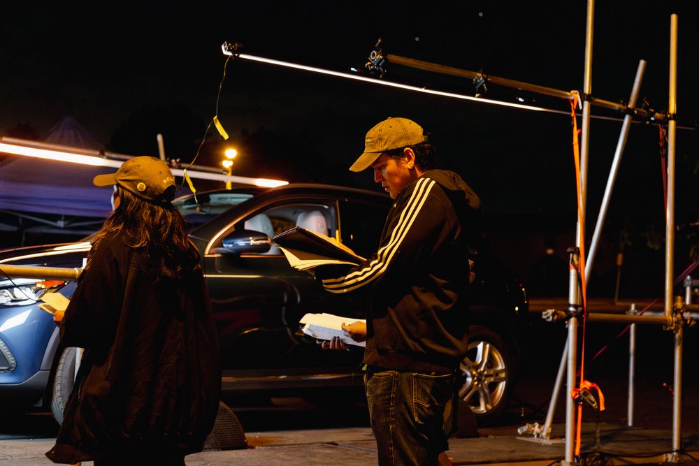 Camera equipment and production gear silhouetted against dark night sky.