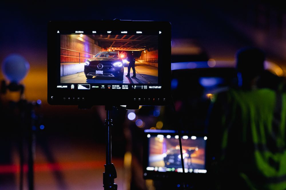Video monitor displays low light footage of a nighttime law enforcement scene.