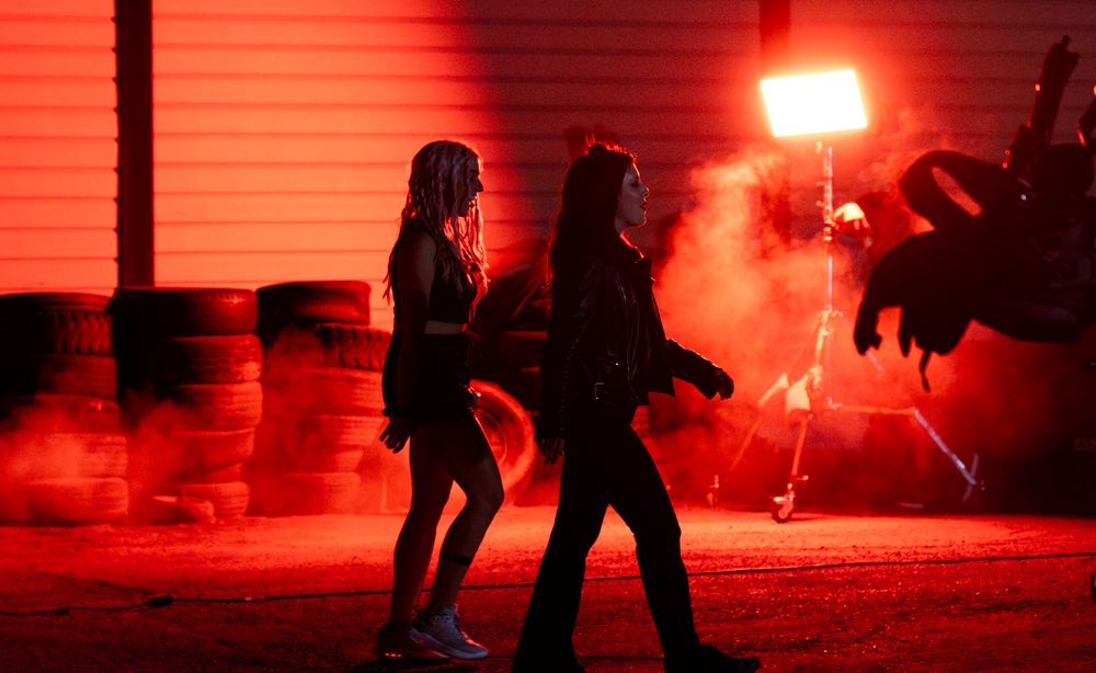 Figures moving through intense red lighting effects during nighttime shoot.