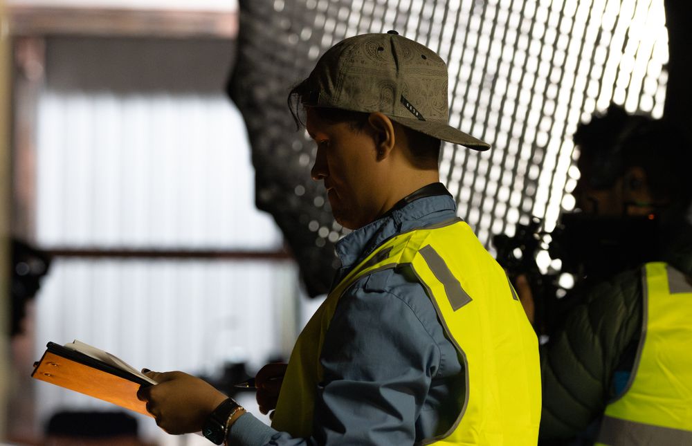 Film crew wearing safety vests working on a production set.