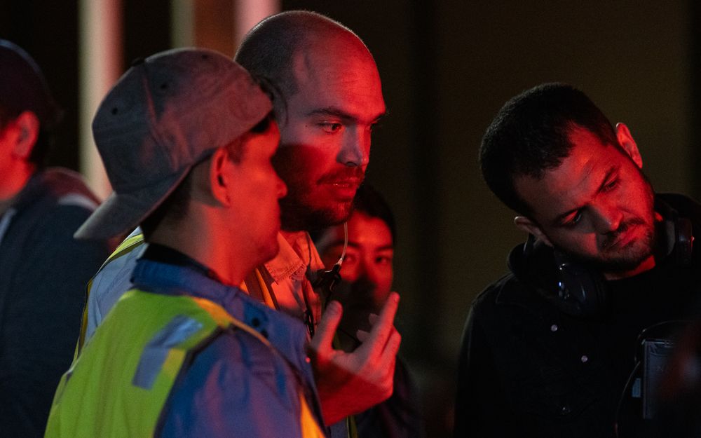 Production crew members working in dim lighting conditions.