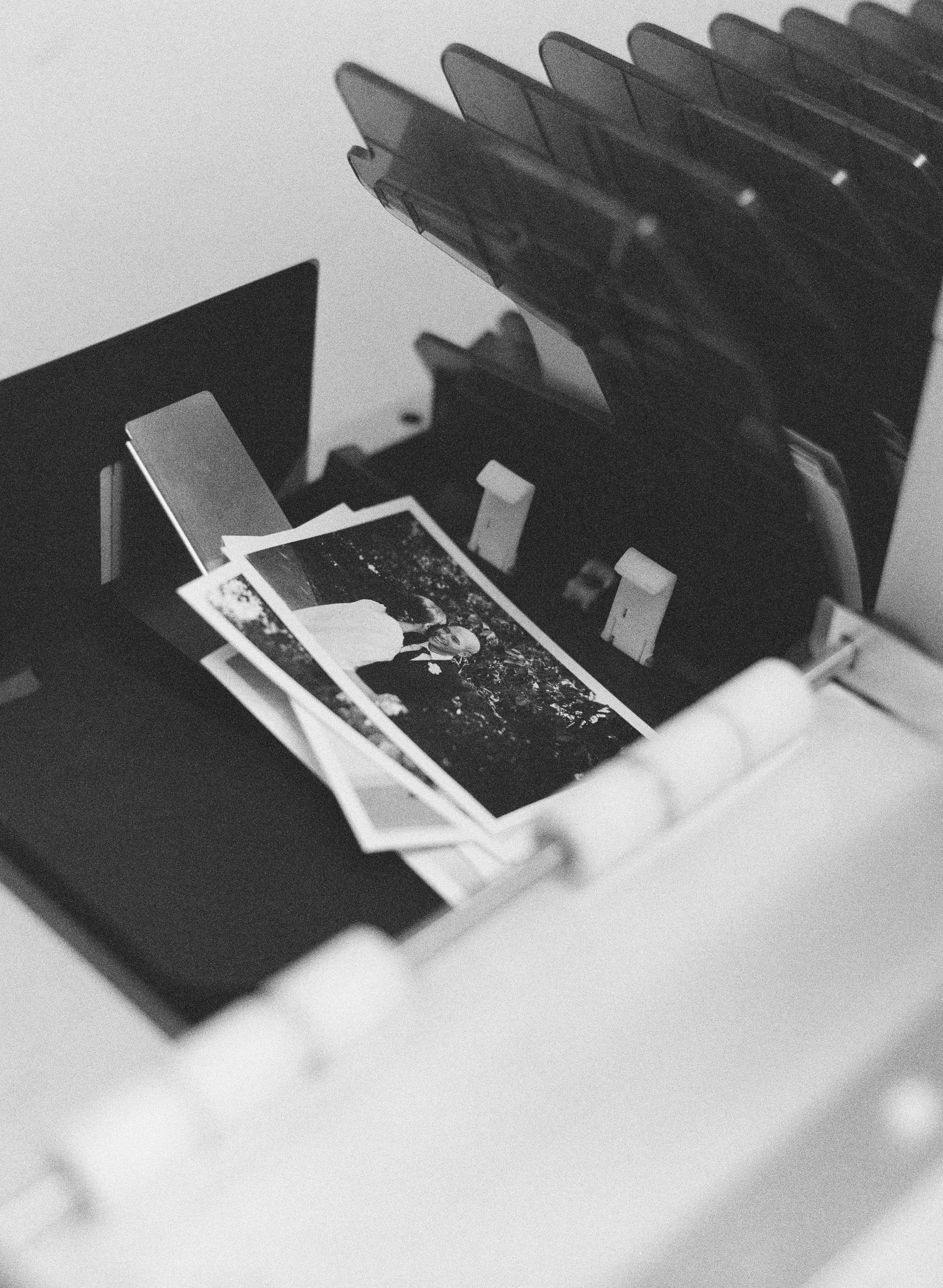 Black and white image of photos being developed in a darkroom setting.